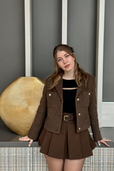 a lady in a brown jacket and a brown skirt